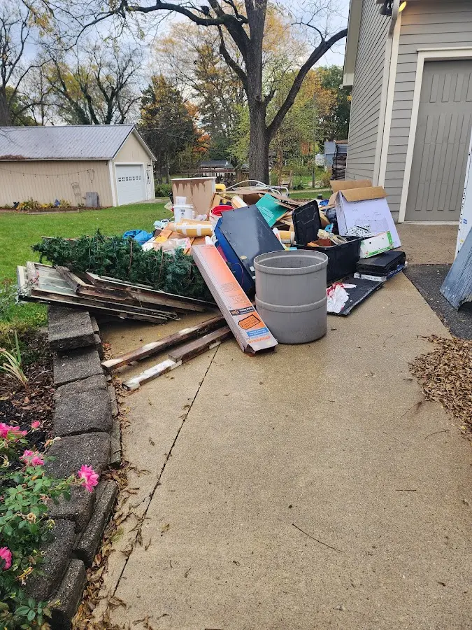 Dumpster being loaded with debris for 12 Yard Dumpster Rental in Holt